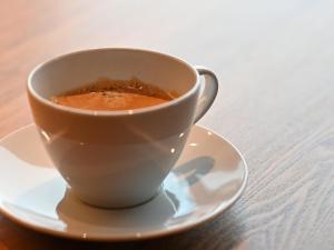 eine Tasse Kaffee auf einem Teller auf einem Tisch in der Unterkunft Chalet Shiga in Yamanouchi