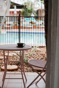 una mesa y sillas junto a una piscina en The Continental Hotel en Broome