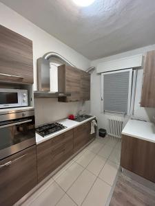 La cuisine est équipée de placards en bois et d'un four avec plaques de cuisson. dans l'établissement Appartamento in villetta a 2 passi dal mare e dal centro, à Pesaro