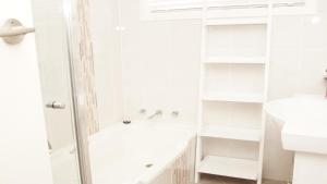 a white bathroom with a shower and a sink at Pet Friendly Cockatoo Corner in Armidale