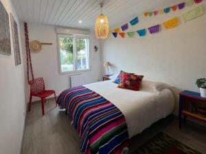 um quarto com uma cama, uma cadeira e uma janela em Jolie Villa avec piscine chauffée 8 par 4 m em Erdeven