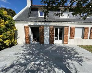uma entrada em frente a uma casa com garagem em Jolie Villa avec piscine chauffée 8 par 4 m em Erdeven