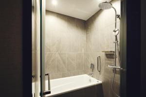 La salle de bains est pourvue d'une douche, d'une baignoire et d'un lavabo. dans l'établissement Hotel Indigo Tokyo Shibuya, à Tokyo