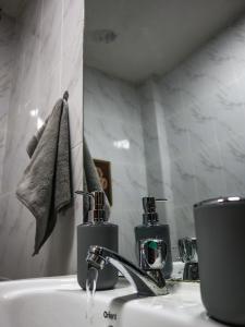 a bathroom sink with two soap dispensers on it at Stunning 1-Bedroom Apartment in Madaraka Estate, Nairobi in Nairobi