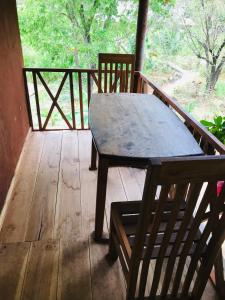 einen Holztisch und eine Bank auf einer Veranda in der Unterkunft Gaga addara resort in Habarana