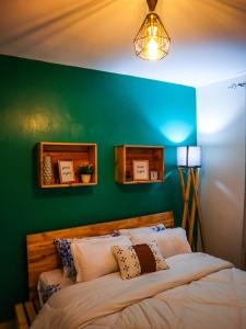 a bedroom with a green wall and a bed at Stunning 1-Bedroom Apartment in Madaraka Estate, Nairobi in Nairobi
