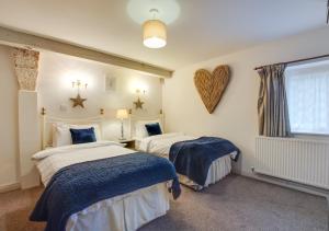 a bedroom with two beds and a heart on the wall at Woodpecker Cottage in Pateley Bridge