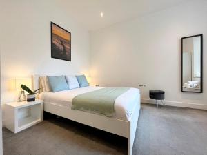 a bedroom with a large bed and a mirror at Spacious Apartment~Parking~Close to Seafront in Penzance