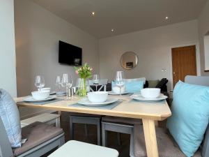 a dining room table with wine glasses and flowers on it at Spacious Apartment~Parking~Close to Seafront in Penzance