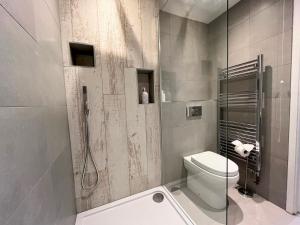a bathroom with a toilet and a glass shower at Spacious Apartment~Parking~Close to Seafront in Penzance