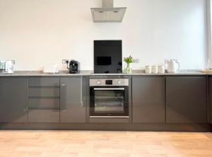 a kitchen with gray cabinets and an oven at Spacious Apartment~Parking~Close to Seafront in Penzance
