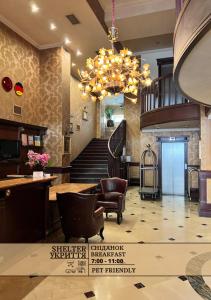 a lobby with a staircase and a chandelier at Frapolli Hotel in Odesa