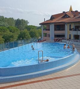una gran piscina con gente en el agua en GiòHome - best apartment, en Grado