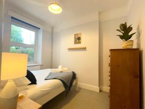 a small bedroom with a bed and a window at Bright & Spacious Edwardian Townhouse with Garden in Truro
