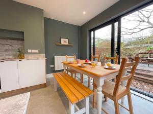 a kitchen and dining room with a wooden table and chairs at Bright & Spacious Edwardian Townhouse with Garden in Truro