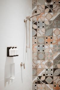 a bathroom with a shower with a tile wall at The Continental Hotel in Broome