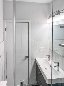 bagno bianco con doccia e lavandino di Yanne's Place - Dual-Lounge a Philadelphia