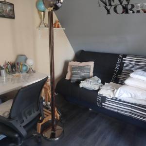 a living room with a black couch and a desk at Home City House confort in Entrevennes