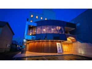 un bâtiment avec un panneau devant lui la nuit dans l'établissement Ninohe City Hotel - Vacation STAY 36054v, à Ninohe
