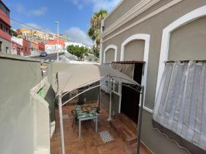 a patio with a table and an umbrella on a balcony at Casa Almendra in Santa Cruz de Tenerife