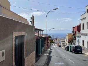 een lege straat in een stad met geparkeerde auto's bij Casa Almendra in Santa Cruz de Tenerife