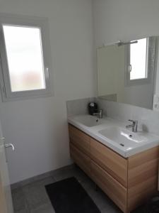 a bathroom with a sink and a mirror at Maison située entre plage la mine d'or et bourg in Pénestin