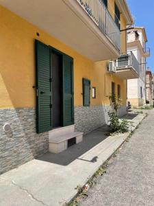 een geel gebouw met een groene deur en een trap bij Casa vacanze “Portanova” in Guglionesi