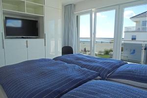 - 2 lits dans une chambre avec vue sur la plage dans l'établissement Brandung, à Olpenitz