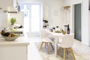 eine Küche mit einem weißen Tisch und weißen Stühlen in der Unterkunft Schwalbennest in Flensburg