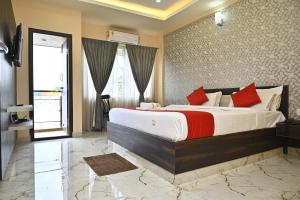 a bedroom with a large bed with red pillows at SB Golden Cherry in Yelahanka