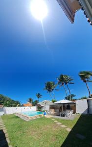 een huis met een zwembad en palmbomen bij Linda Casas 5/4 Praia de Vilas do Atlântico !!! in Lauro de Freitas