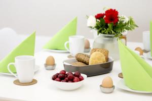 - une table avec des œufs, des biscuits et un vase de fleurs dans l'établissement Auster, à Flensbourg