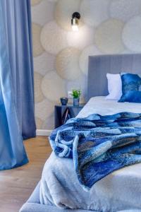 ein Schlafzimmer mit einem Bett mit einer blauen Decke darauf in der Unterkunft Asaapart Lamiya 2-72А in Almaty