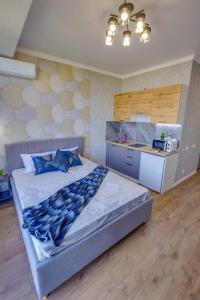 1 Schlafzimmer mit einem großen Bett und einer Küche in der Unterkunft Asaapart Lamiya 2-72А in Almaty