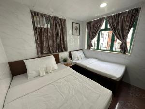 a small room with two beds and a window at Mandarin Guest House in Hong Kong