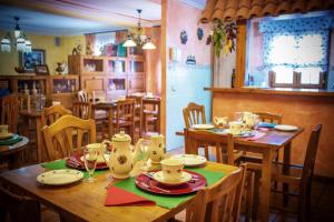 un comedor con una mesa de madera con platos y vasos en Hosteria Los Laureles, en Noja