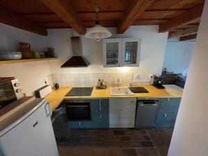 a kitchen with blue cabinets and a sink at Chez Sári in Sarud