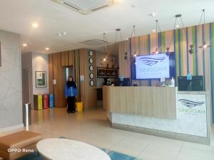 a woman standing behind a counter in a lobby at Singgah Pengerang Hotel in Pengerang