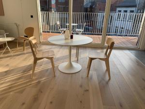 een tafel en 2 stoelen in een kamer met een raam bij #2800ourhome 301 in Mechelen