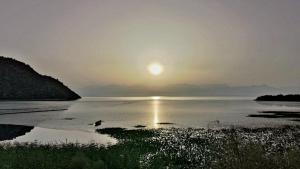 a sunset over a body of water with the sun in the sky at Apartment Lake Oasis ''Oko'' in Krnjice +23 photos