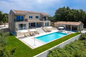 a villa with a swimming pool and a house at Levlante in Kanfanar
