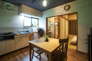 cocina con mesa de madera y comedor en Kagurazaka Retro BAR & HOTEL, en Tokio