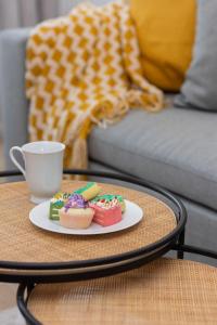 a table with a plate of cupcakes and a coffee mug at Modern & Bright Apartment with Parking and Balcony by Renters in Warsaw