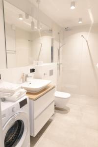 bagno bianco con lavatrice di Apartamenty Szkolna a Żnin