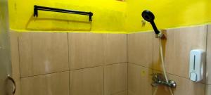 baño con ducha y secador de pelo en la pared en Ruteng Hostel en Ruteng