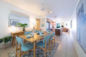 comedor y sala de estar con mesa y sillas en Sun View On Seaview - Airlie Beach, en Airlie Beach