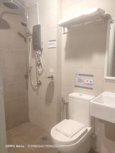 a bathroom with a shower with a toilet and a sink at Singgah Pengerang Hotel in Pengerang