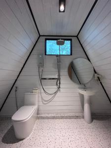 La salle de bains est pourvue de toilettes, d'un lavabo et d'une fenêtre. dans l'établissement Camping Park Resort, à Kampong Speu