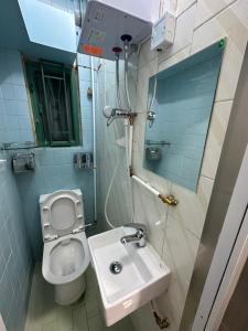a small bathroom with a toilet and a sink at Mandarin Guest House in Hong Kong