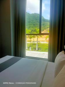 a bedroom with a bed and a large window at Singgah Pengerang Hotel in Pengerang